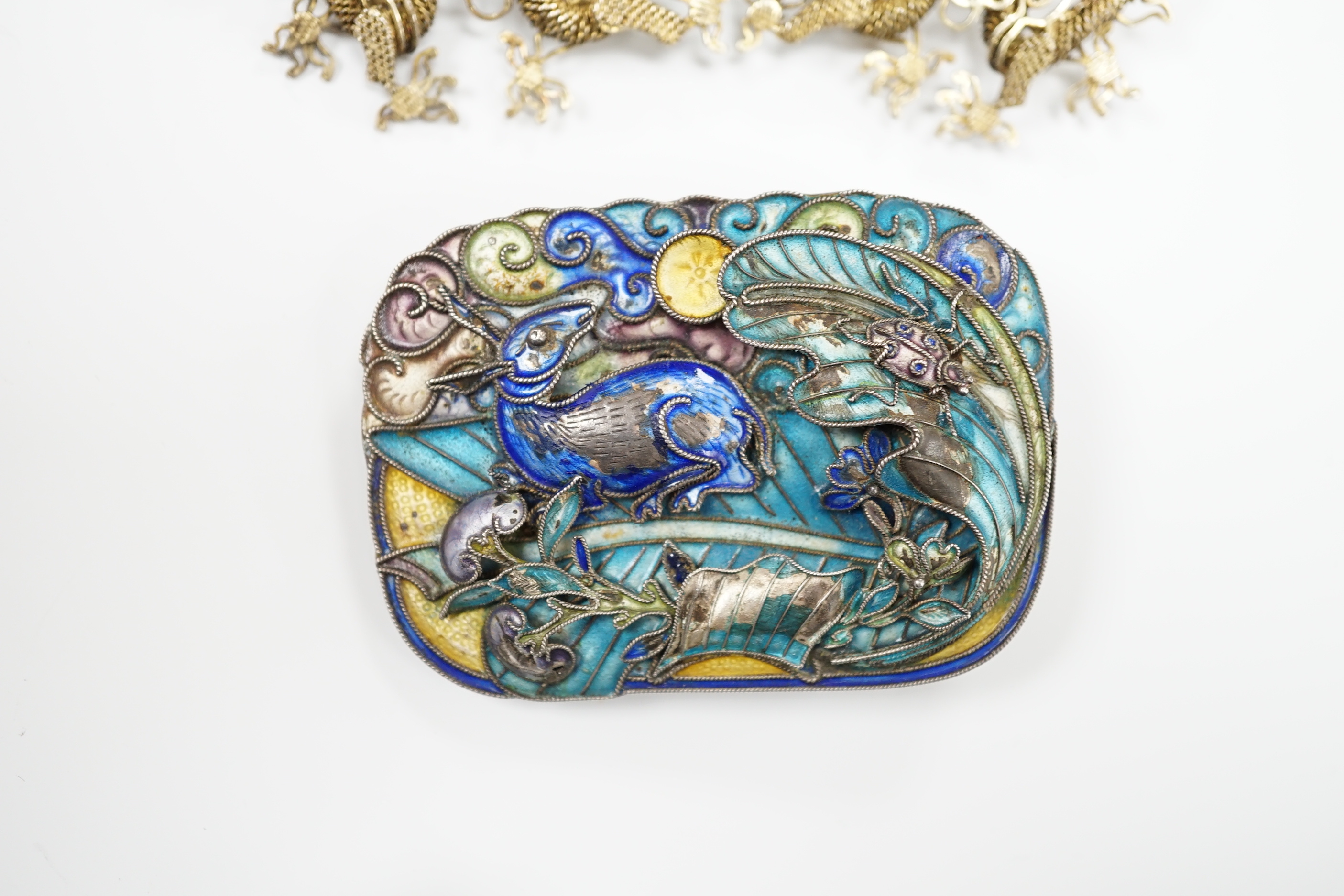 A Chinese? white metal and polychrome enamelled brooch, depicting a hare amongst foliage, 59mm(a.f.), together with a similar gilt white metal filigree and cabochon green paste set brooch.